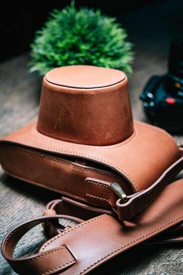Oberwerth Crossbody Holster in braunem Leder, geschlossen auf Holztisch