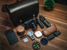 Packbeispiel der Oberwerth Signature Bag L mit Kamera, Objektiven und Zubehör auf Holztisch