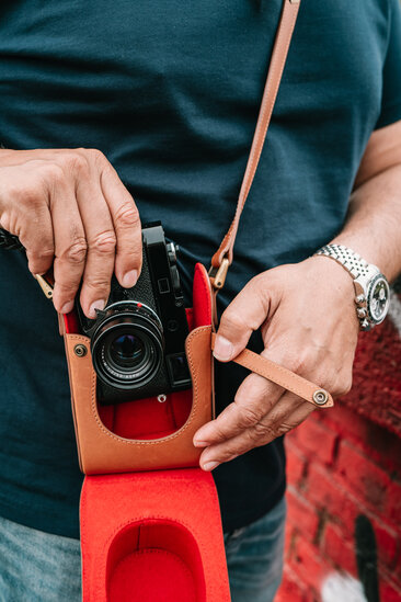 Leica M Kamera wird aus dem Crossbody Holster aus Leder entnommen
