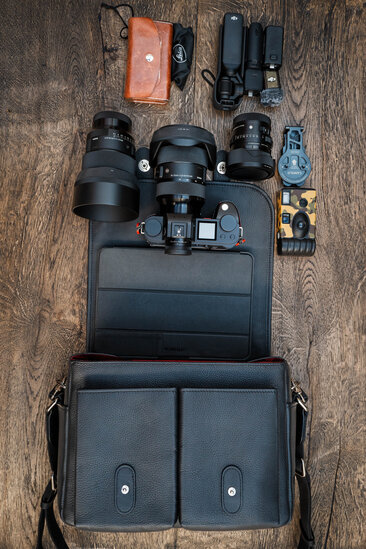 Flatlay eines umfangreichen Leica SL Kamera-Setups neben der Oberwerth Little William Kameratasche