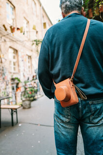 Oberwerth Crossbody Holster in braunem Leder auf dem Rücken getragen, urbaner Hintergrund mit Streetart